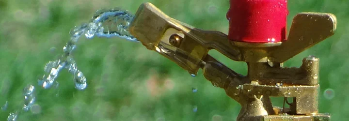 Arroseur de surface posé au milieu d'une pelouse