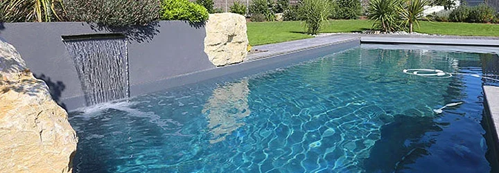 Piscine avec cascade et margelles en pierre